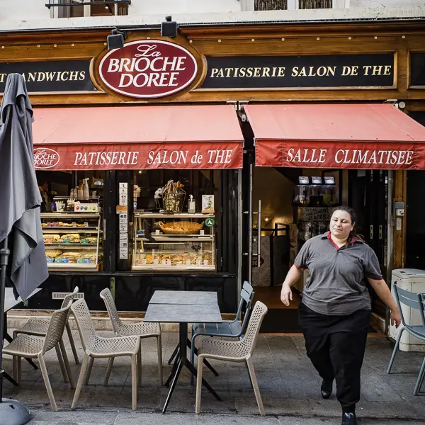 An employee tends the tables at La Brioche Dorée, a popular chain of bakery-cafés that has branches all over France.